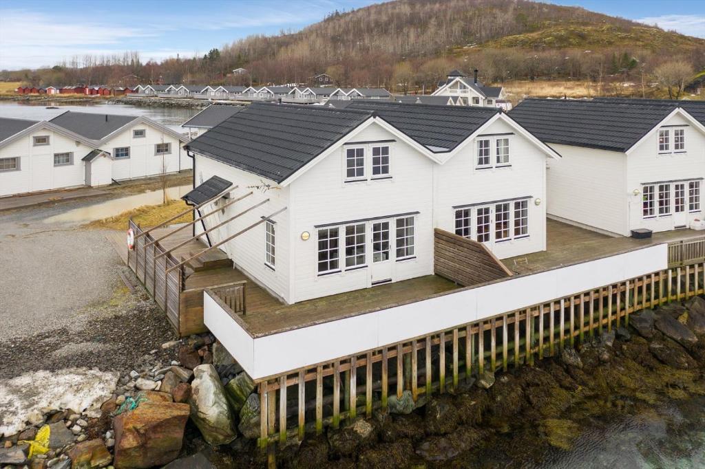 Ein weißes Haus auf einer Brücke über einen Wasserkörper in der Unterkunft Idyllisk sjøhus på Naurstad in Bodø