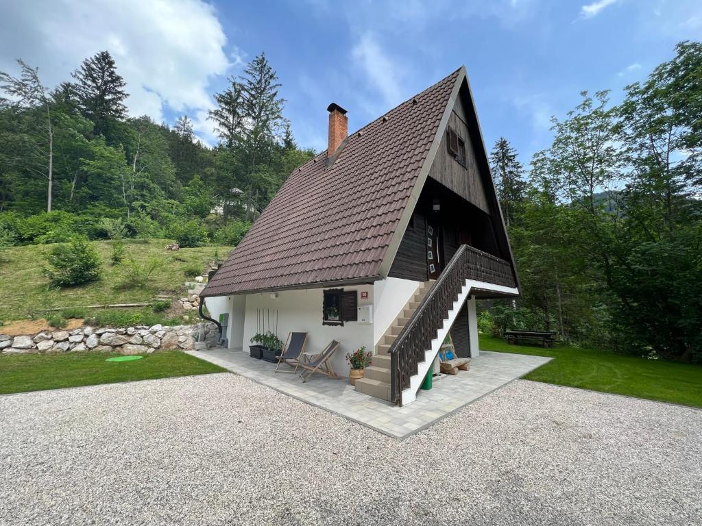 a small house with a brown roof and a patio at Our Forest House in Tržič