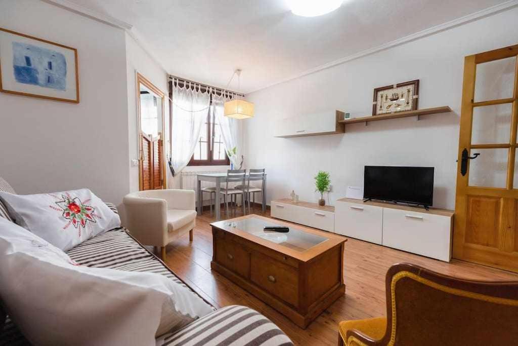 Una sala de estar con un sofá y un televisor. en El apartamentín de Lastres, en Lastres