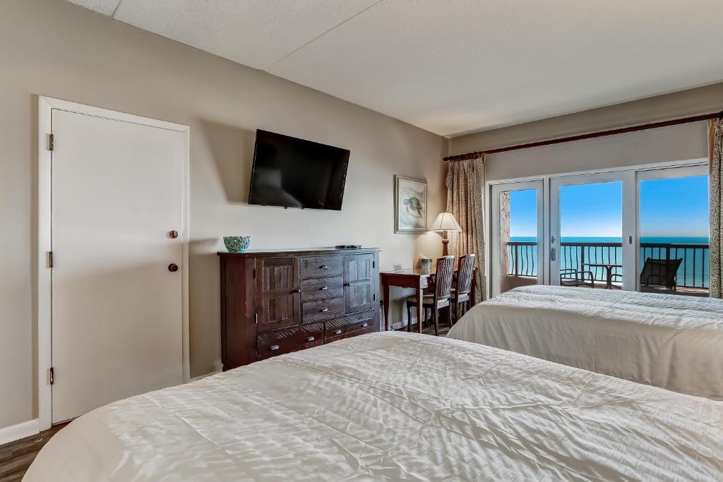 a bedroom with two beds and a view of the ocean at 328 Sandcastle condo in Fernandina Beach