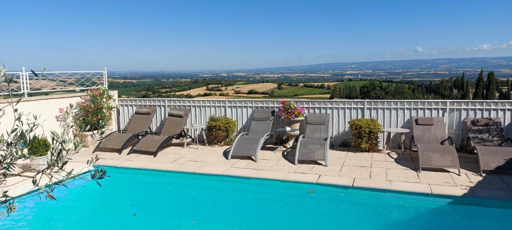 - une piscine avec des chaises longues, une table et une vue dans l'établissement La Belle Vie B&B, à Montréal