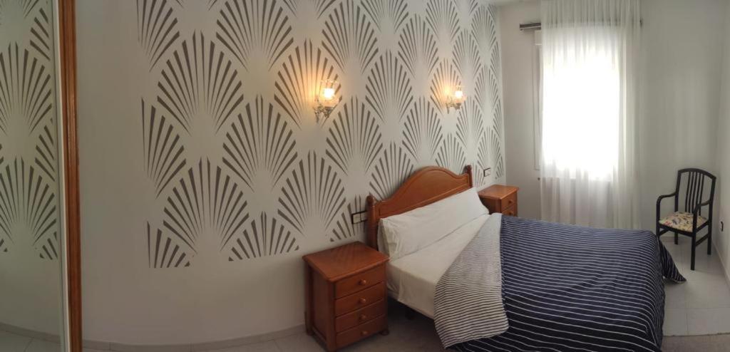 a bedroom with a bed and a patterned wall at Pensión Barqueiras 15 in O Grove