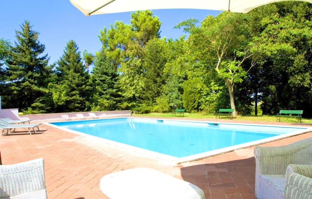 piscina con sedie e ombrellone di One bedroom appartement with shared pool enclosed garden and wifi at Fabriano a Fabriano
