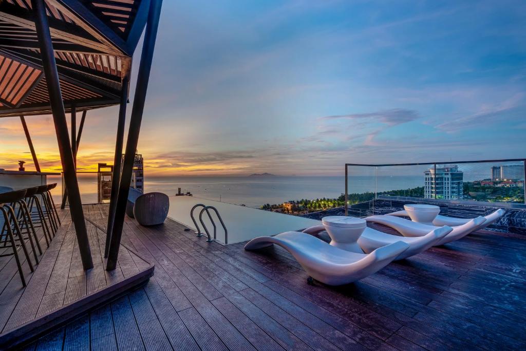 Draco Hotel & Suites في دا نانغ: شرفة مطلة على المحيط وقت الغروب