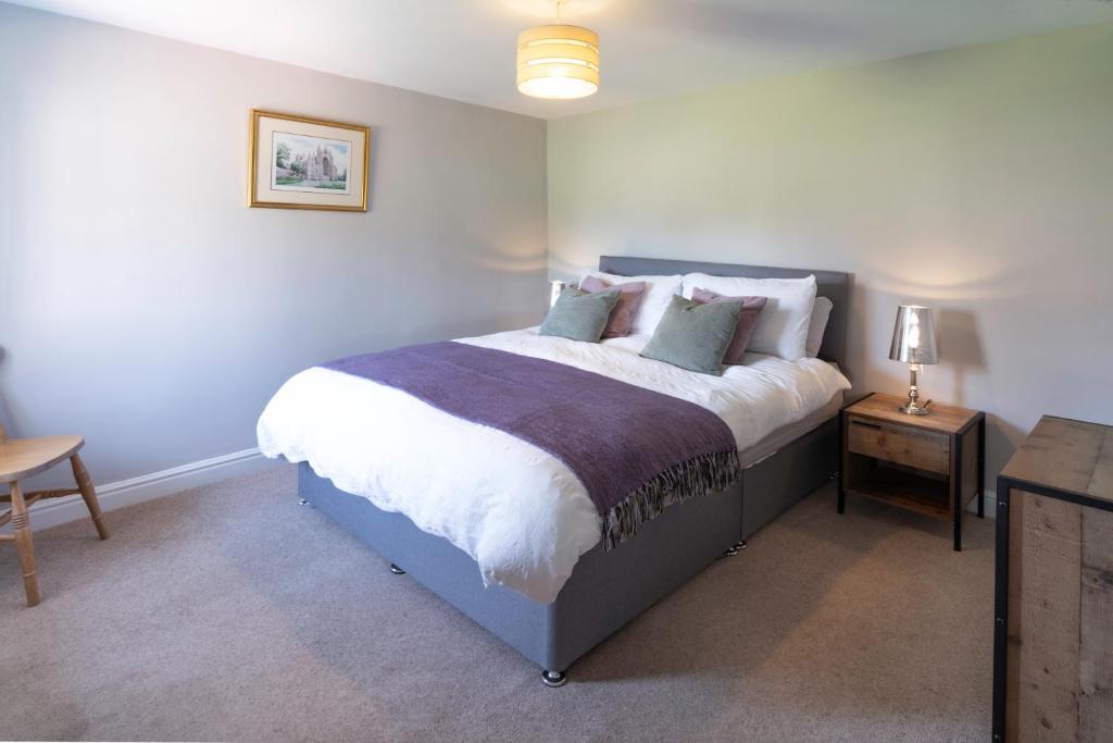 a bedroom with a large bed with white sheets and pillows at Rose Cottage, Eden Valley, Cumbria in Cumwhitton