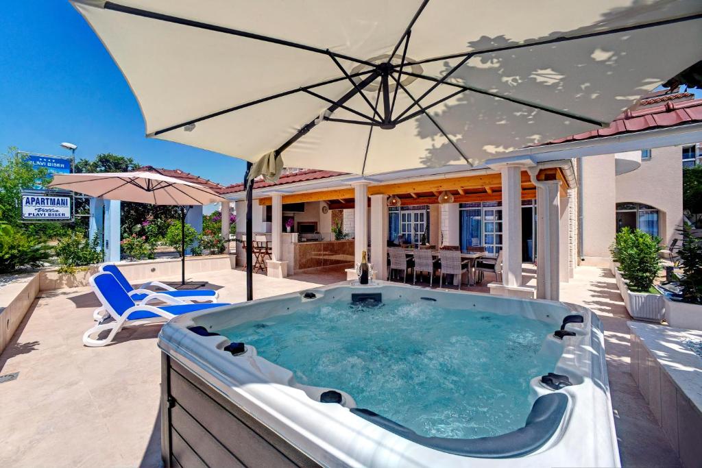 einen Whirlpool auf einer Terrasse mit Sonnenschirm in der Unterkunft Luxury Apartment Plavi Biser in Šibenik