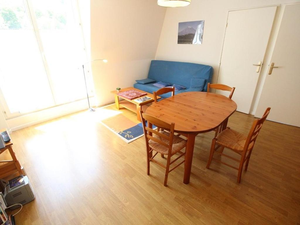uma sala de estar com uma mesa e cadeiras e um sofá em Appartement Bagnères-de-Luchon, 2 pièces, 4 personnes - FR-1-313-135 em Luchon