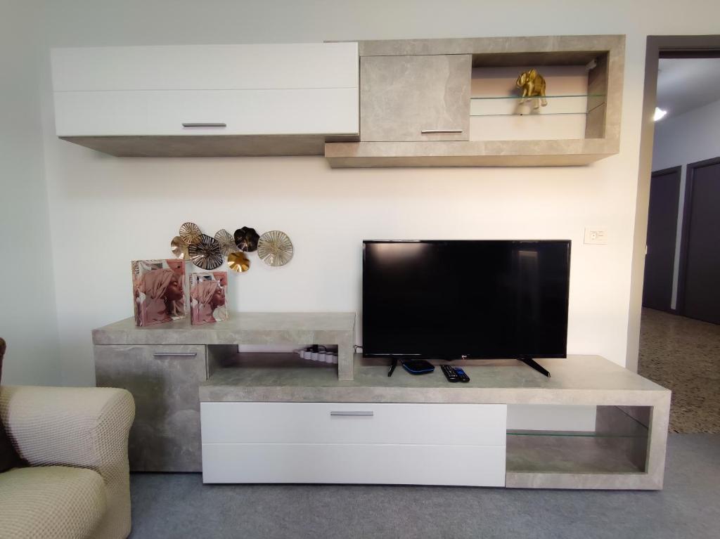 a living room with a flat screen tv on a entertainment center at Vivienda turística Mou in Arzúa