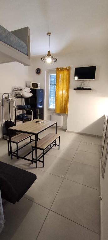 uma sala de estar com uma mesa e cadeiras e uma televisão em Nice Apartment S4 em Nice