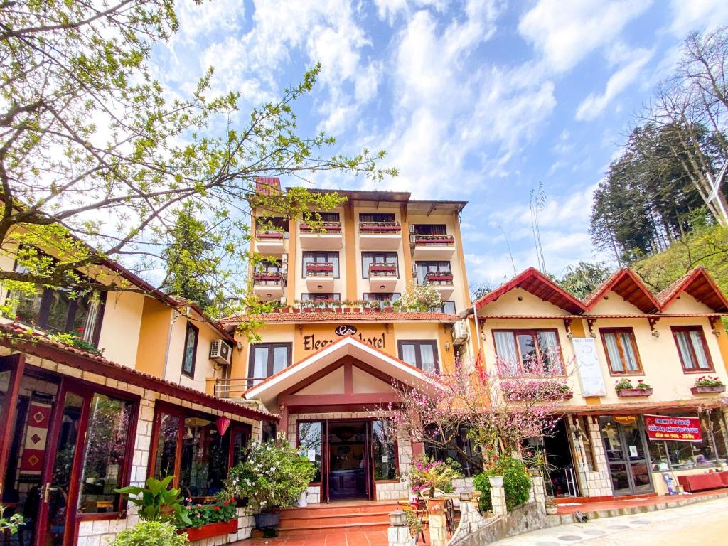 a building on a city street with trees at Sapa Elegance Hotel in Sapa
