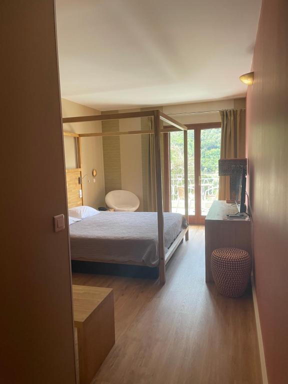 Postel nebo postele na pokoji v ubytování Logis Hotel Le Lonca