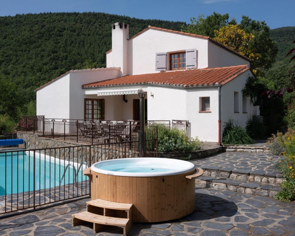 a house with a bath tub in front of a house at Villa La casa del gat in Mosset