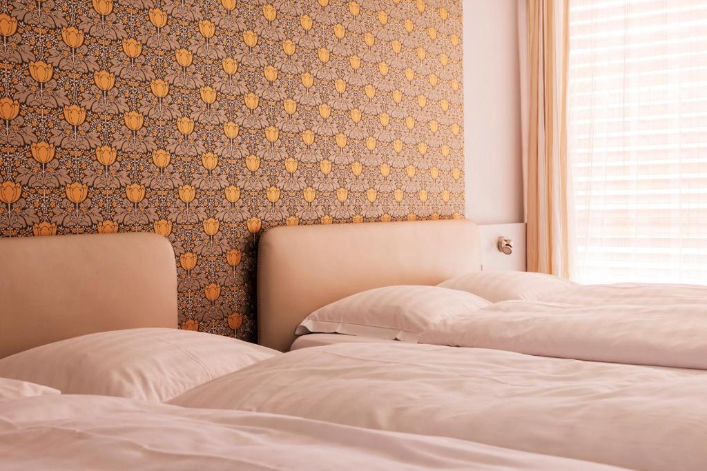 2 Betten in einem Schlafzimmer mit einer Wand in der Unterkunft Rotonda in Gordola