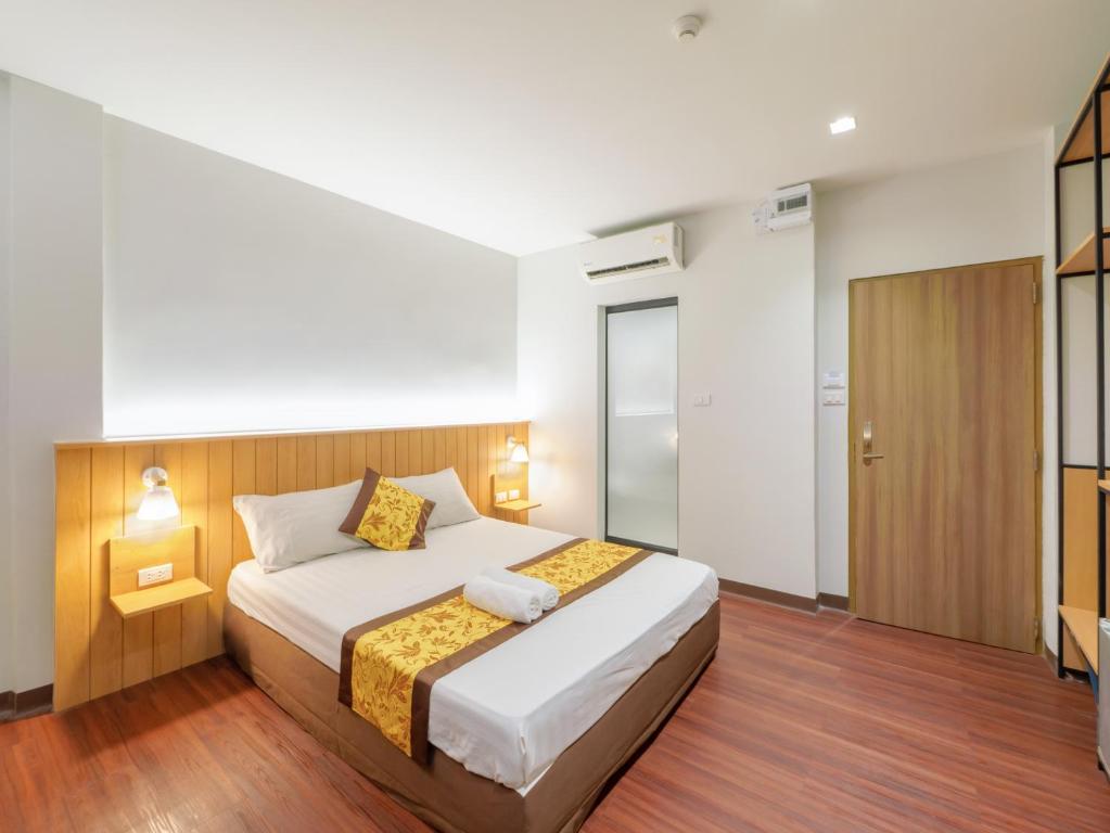 a bedroom with a large bed and a wooden floor at Watergate City in Bangkok