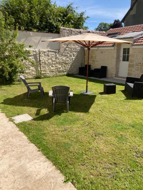 een bank en een paraplu in een tuin bij Appart’hôtel saint patrice in Bayeux