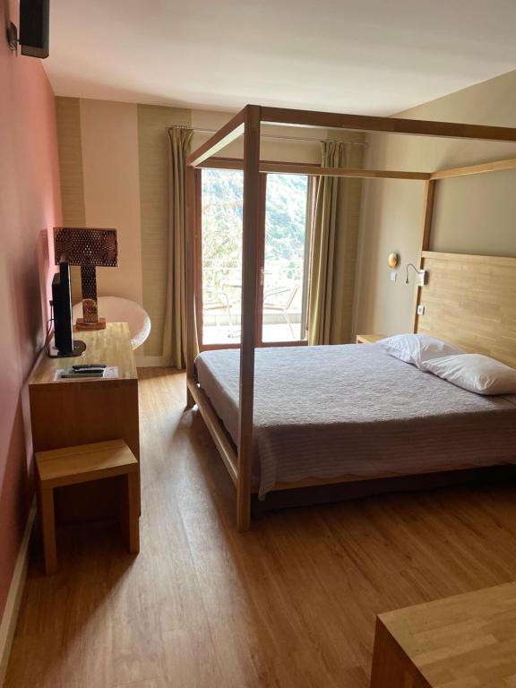 Postel nebo postele na pokoji v ubytování Logis Hotel Le Lonca