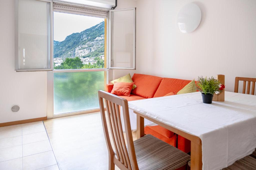 a dining room with a table and a couch at Incantevole appartamento con parcheggio gratuito in Trento
