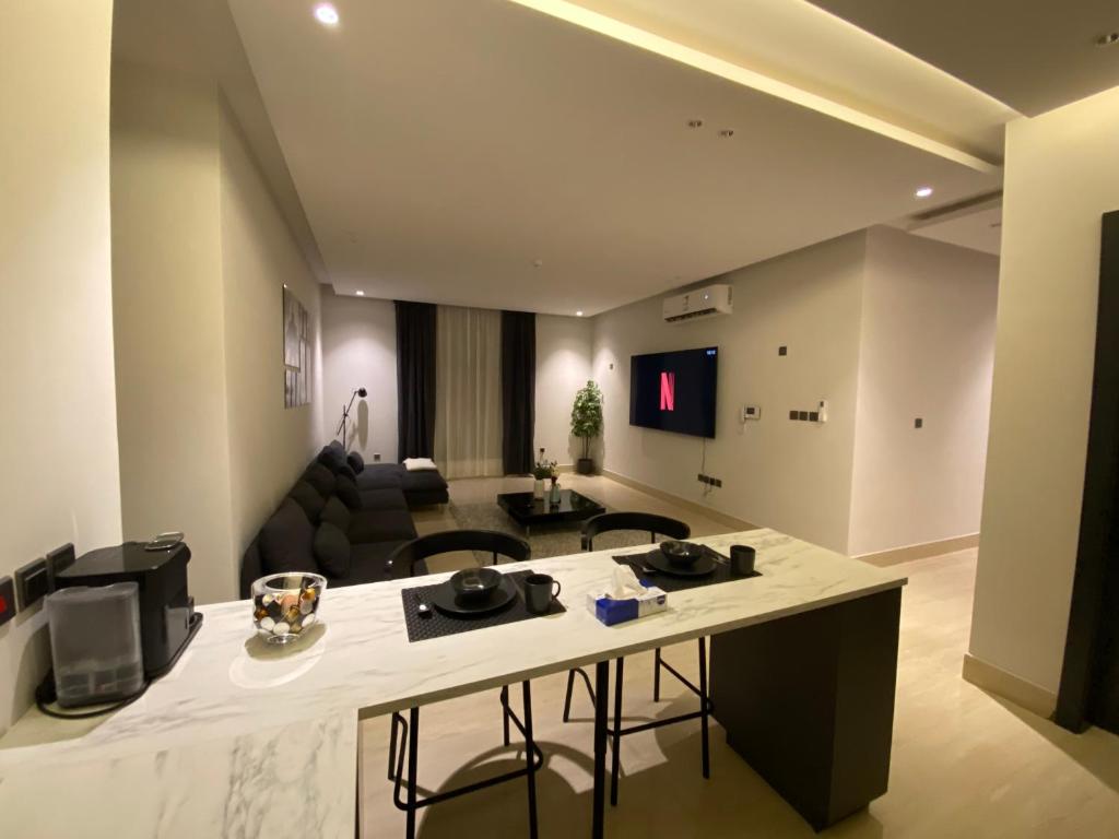 a living room with a kitchen and a couch at 3 - Bedroom Apartment in Riyadh