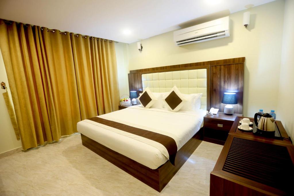 a hotel room with a bed and a desk with a television at Golden Crown Hotel Alseeb Muscat in Seeb