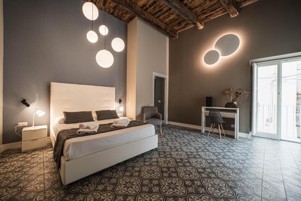 een slaapkamer met een bed en wat verlichting aan de muur bij Palazzo Paladini - Luxury Suites in the Heart of the Old Town in Pizzo