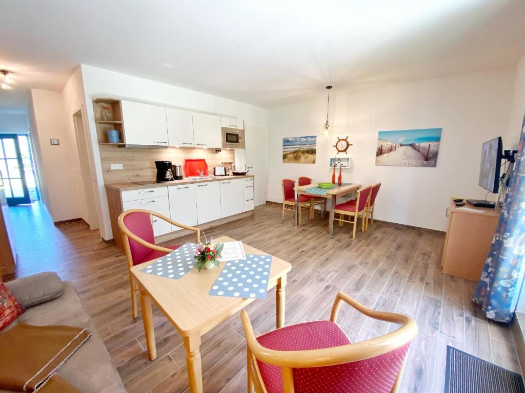 salon ze stołem i krzesłami oraz kuchnię w obiekcie Ferienanlage Kap Arkona - Appartement 22 w mieście Putgarten
