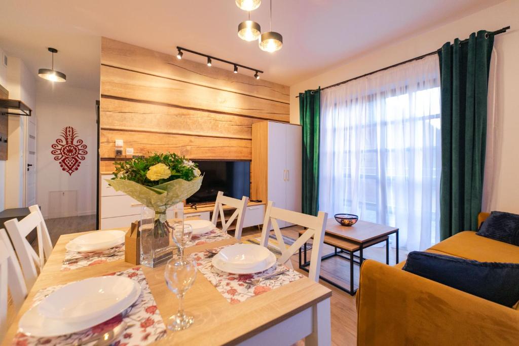 a dining room and living room with a table and chairs at Apartament Liściasty 1 z tarasem - Dream Apart in Ustroń