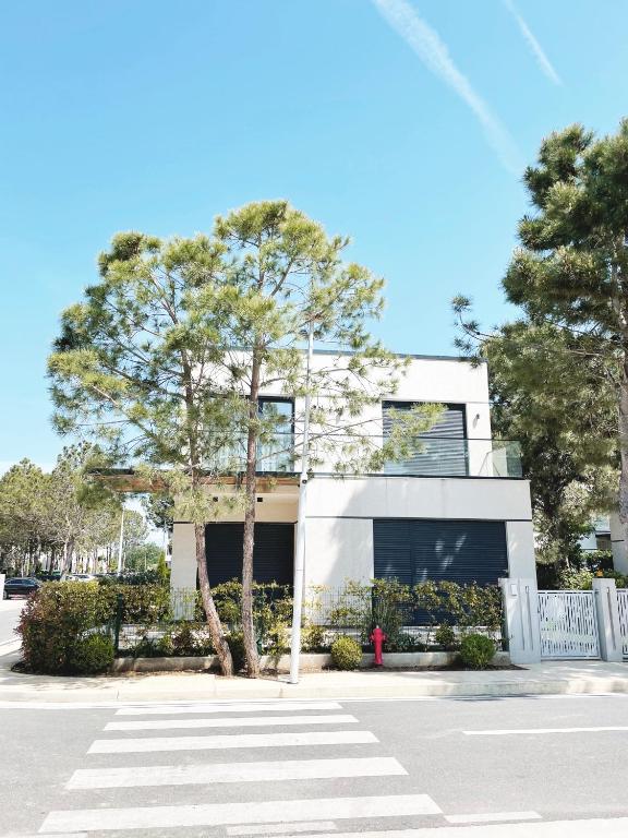 a white building with a tree in front of it at Sea't La Vie Villas in Hamallë