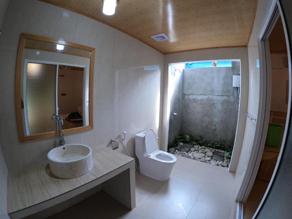 a bathroom with a sink and a toilet at Blue Water Thoddoo Inn in Thoddoo