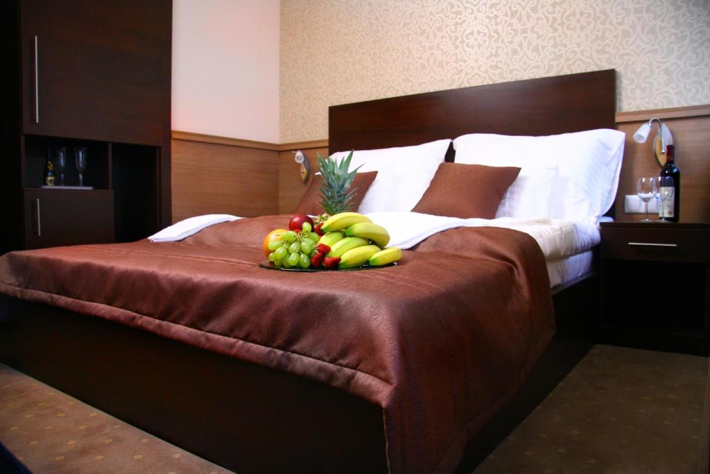 ブダペストにあるCentral Hotel 21 and Apartmentsのホテルのベッドの上にフルーツの盛り合わせ