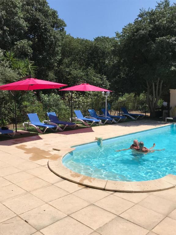 - une personne se baignant dans une piscine avec des chaises longues et des parasols dans l'établissement Gites de la Massane, à Argelès-sur-Mer