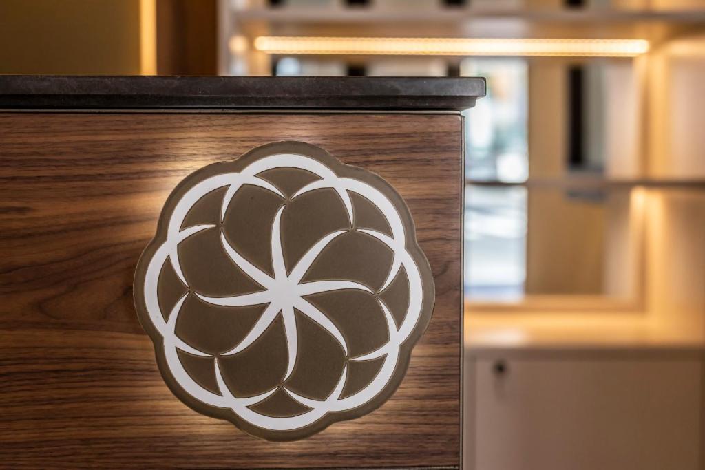a sign on a wooden door with a flower on it at Solmaris Tropea Rooms & Suites in Tropea