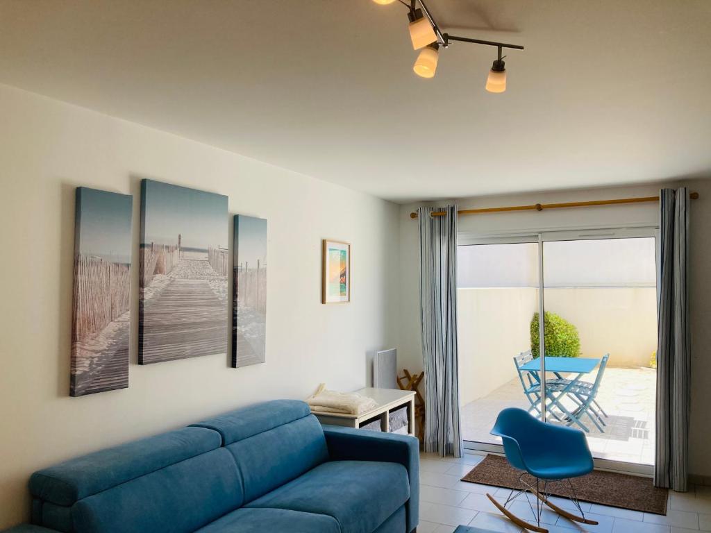 ein Wohnzimmer mit einem blauen Sofa und einem blauen Stuhl in der Unterkunft Maison de l'océan, convivialité et plage à 300m in Saint-Jean-de-Monts