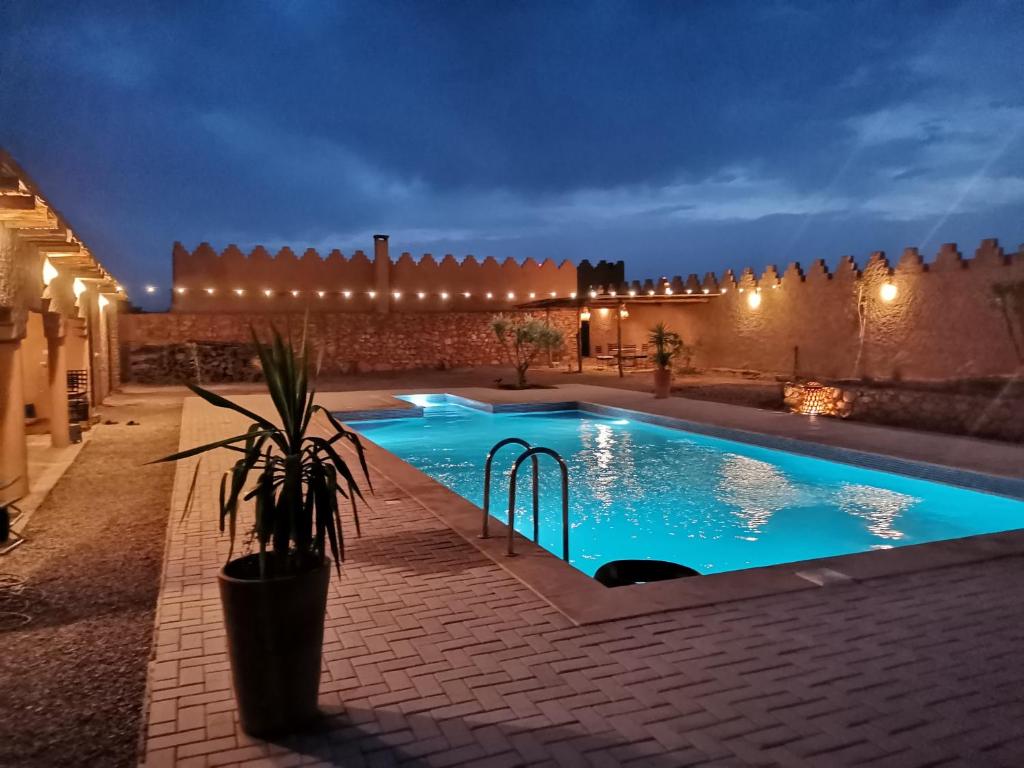 a swimming pool in a courtyard at night at Ksar Montana Gîtes, Chambres piscine in Taforhalt