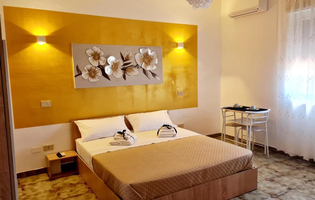 una habitación de hotel con una cama y flores en la pared en Le Terre di Sicilia en Terrasini Favarotta