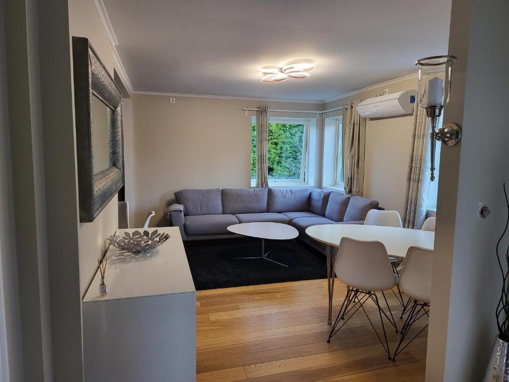 uma sala de estar com um sofá azul e uma mesa em Nesttunveien appartments em Bergen