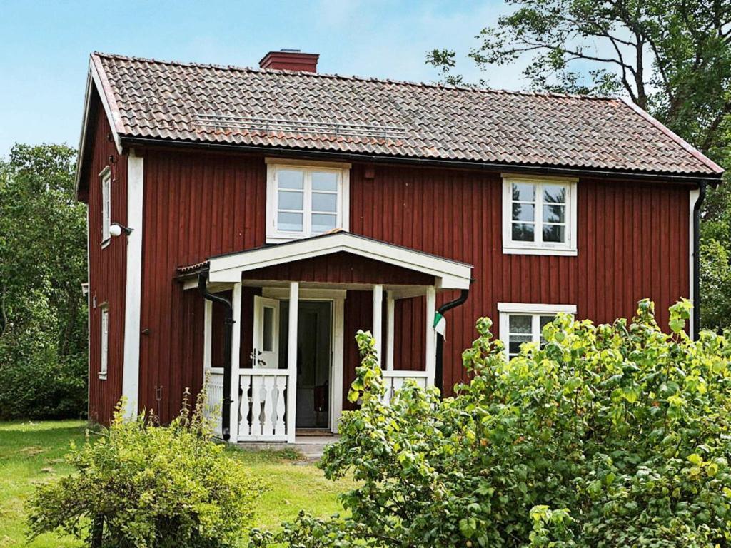 a red house with a white door at 5 person holiday home in LOFTAHAMMAR in Loftahammar