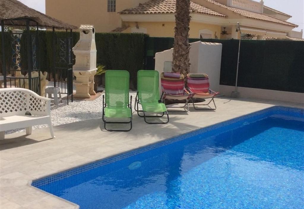 grupa krzeseł ustawionych obok basenu w obiekcie Casa Cuesta w mieście Bolnuevo