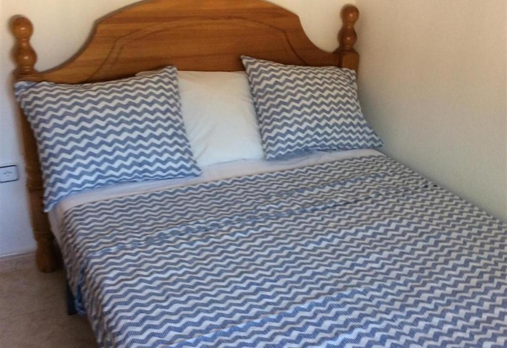 łóżko z niebiesko-białą pościelą i poduszkami w obiekcie Casa Cuesta w mieście Bolnuevo