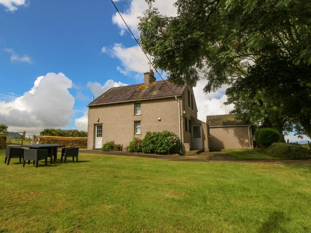a house with a picnic table in the yard at Garreg Lwyd Farm in Pwllheli