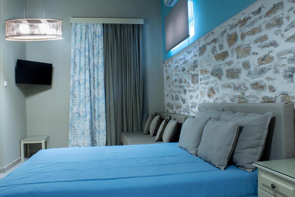 a bedroom with a blue bed and a couch at AFISSOS SEASIDE STUDIOS in Afissos