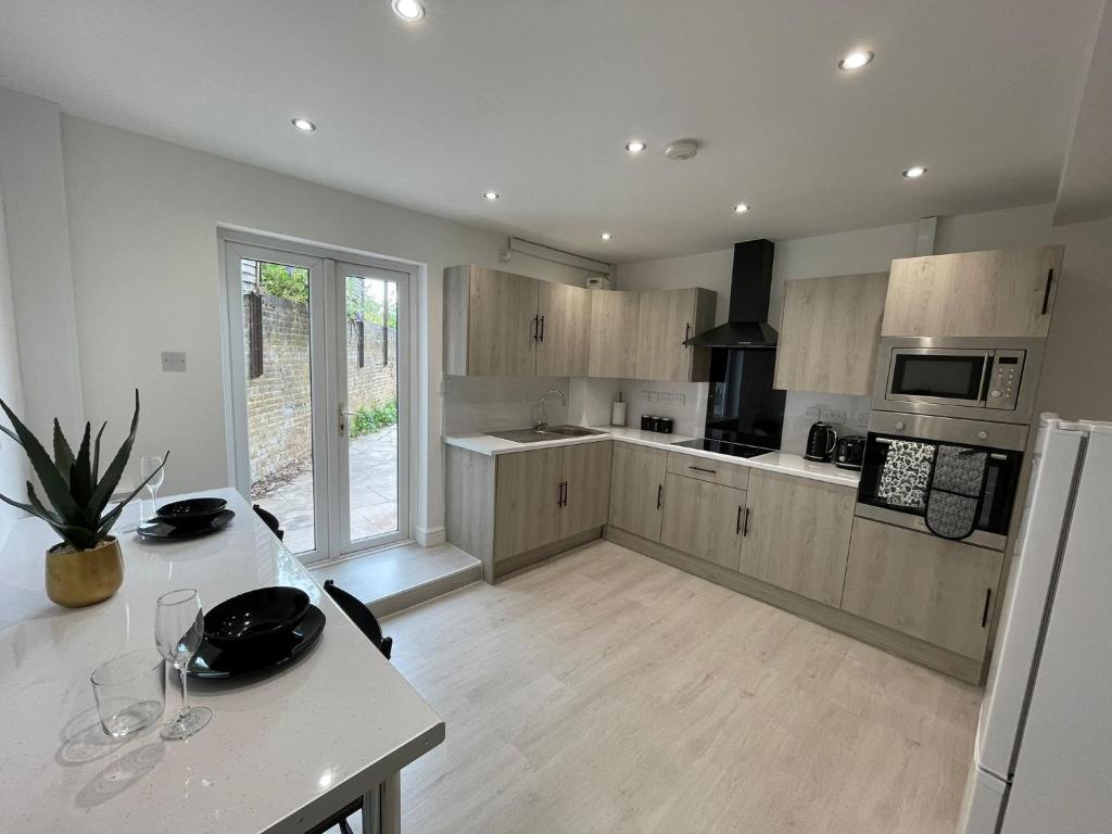 una cucina con armadi in legno e un tavolo con bicchieri di ED Executive Ipswich Accommodation a Ipswich