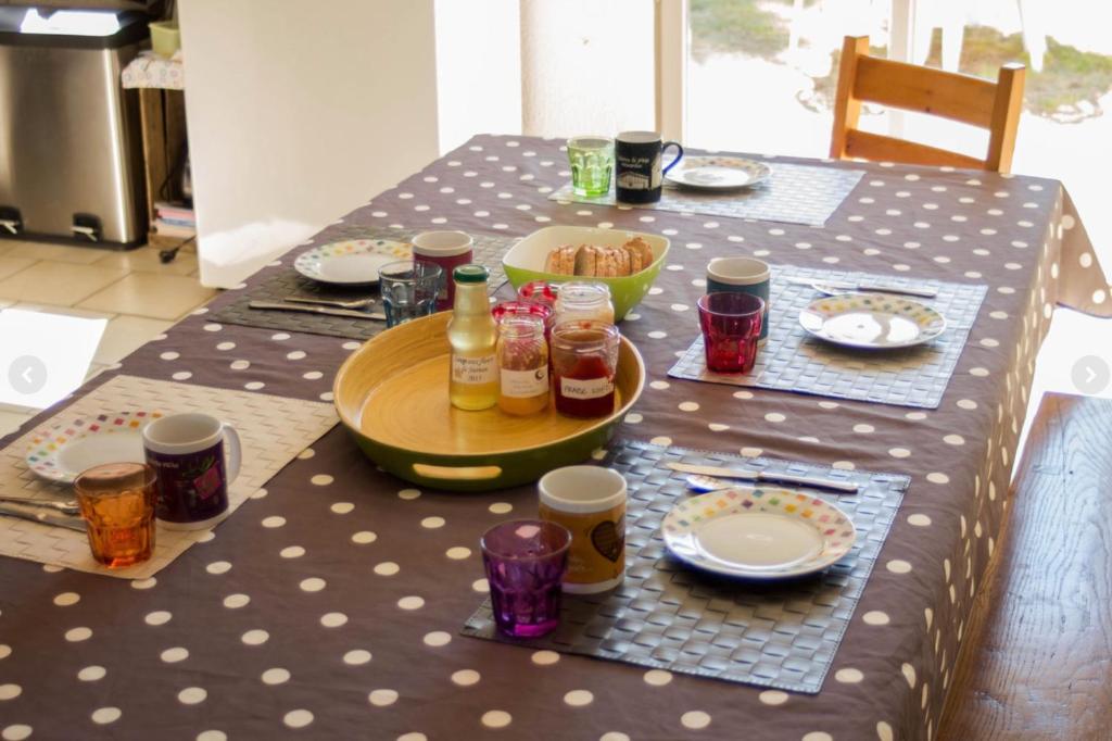 a table with plates of food and drinks on it at Chambres d'Hôtes Lefoulon in Pirou