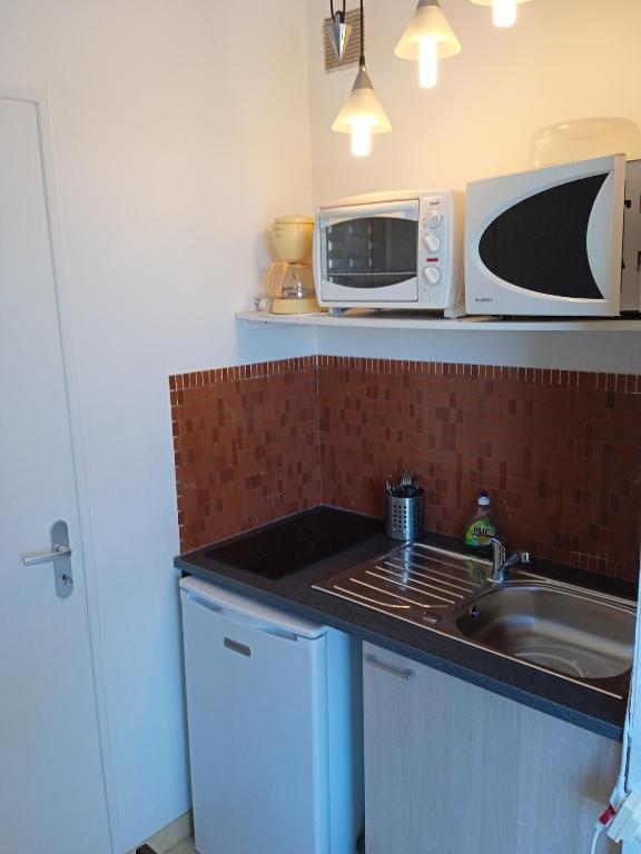 a kitchen with a sink and a microwave at Studio - Marina 6 - 35 allée des Pinons - 3-1 in Saint-Jean-de-Monts