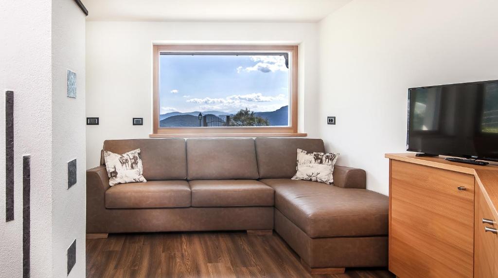 ein Wohnzimmer mit einem Sofa und einem Fenster in der Unterkunft Avea App 1 in Lajen