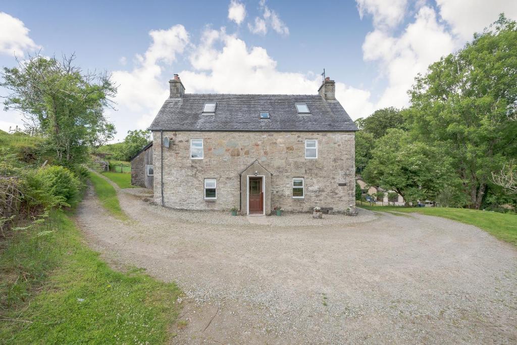 una vieja casa de piedra en un camino de grava en Smithy House, en Lochgilphead