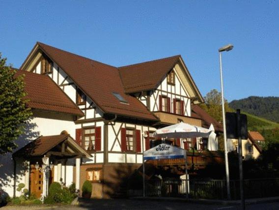 a large house with a brown and white building at Hotel Restaurant Adler Bühlertal in Bühlertal