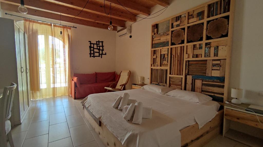 a bedroom with a large bed and a red couch at Le Zagare di Vendicari in Noto Marina