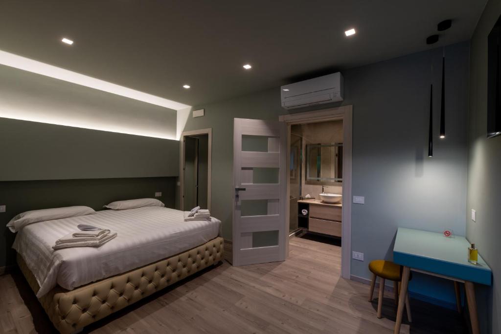 een slaapkamer met een bed en een badkamer met een wastafel bij DiVino Rooms Deluxe in Sabbio Chiese