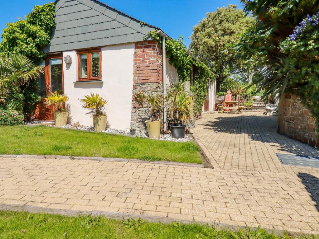 a brick cottage with a brick driveway at Cameo in Bude