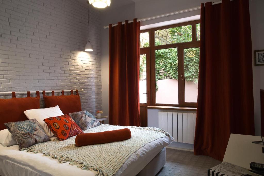 una camera da letto con letto, cuscini e finestra di Sweet Garden Hotel a Baku